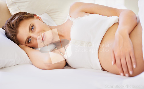 Image of Pregnant woman, love stomach and portrait on bed with relax wellness and mindfulness for prenatal care. Person, smile face and connect for pregnancy gratitude, rest and maternity touch in apartment