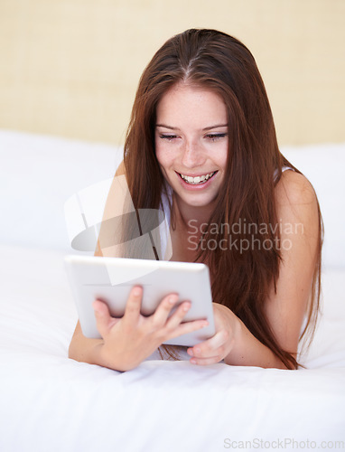 Image of Woman, tablet and relax on bed with internet, social media or online streaming service for film choice or movies. Happy young person reading or watch on her digital technology in a bedroom or at home