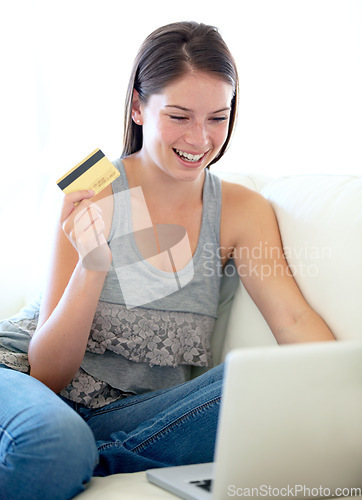 Image of Woman, credit card and laptop on sofa for online shopping sale, e commerce discount or cashback bonus at home. Excited person on couch and internet banking, web registration and typing on a computer