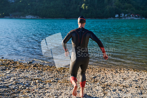 Image of Triathlon athlete starting swimming training on lake