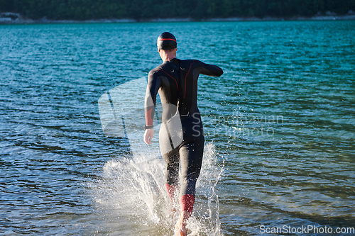 Image of Triathlon athlete starting swimming training on lake