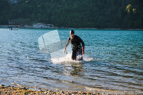 Image of Triathlon athlete starting swimming training on lake