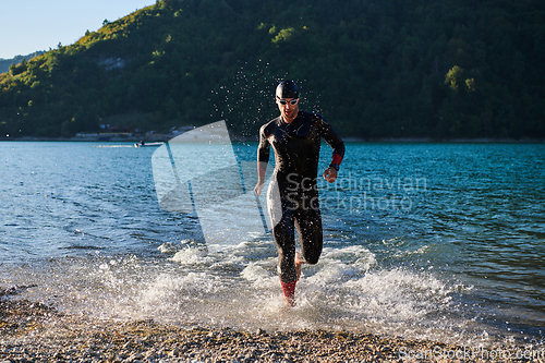 Image of Triathlon athlete starting swimming training on lake