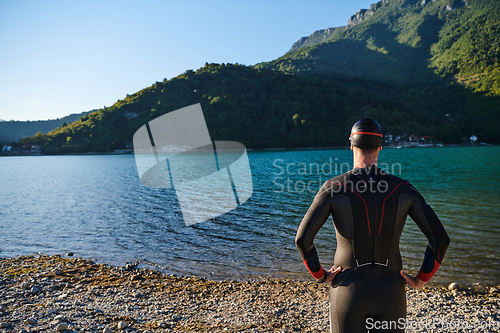 Image of Authentic triathlon athlete getting ready for swimming training on lake