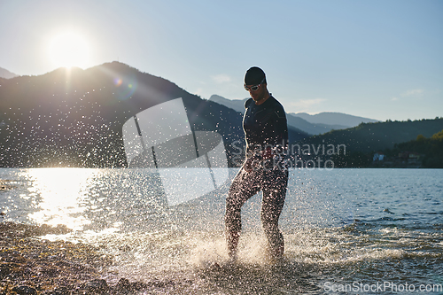 Image of Triathlon athlete starting swimming training on lake