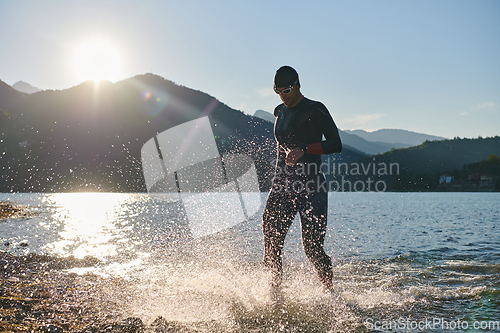 Image of Triathlon athlete starting swimming training on lake