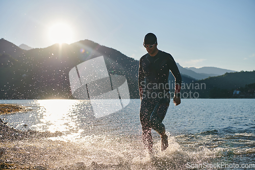 Image of Triathlon athlete starting swimming training on lake