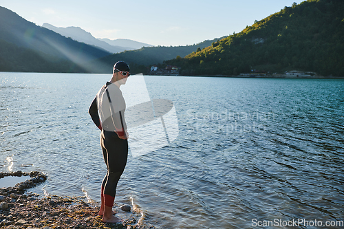 Image of Triathlon athlete starting swimming training on lake