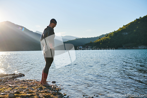 Image of Triathlon athlete starting swimming training on lake