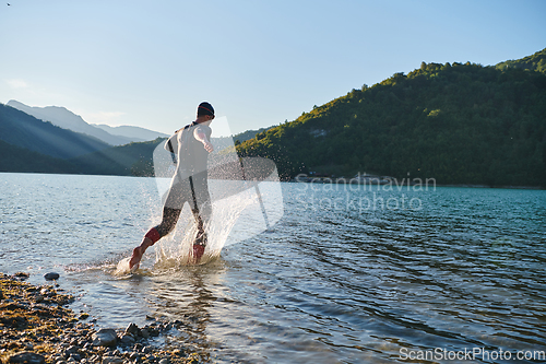 Image of Triathlon athlete starting swimming training on lake