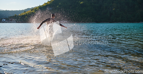 Image of Triathlon athlete starting swimming training on lake