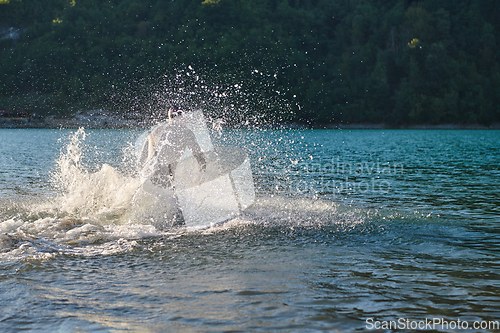 Image of Triathlon athlete starting swimming training on lake