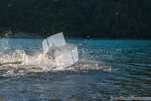 Image of Triathlon athlete starting swimming training on lake