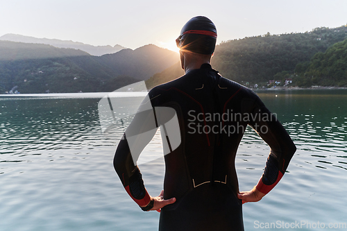 Image of Authentic triathlon athlete getting ready for swimming training on lake