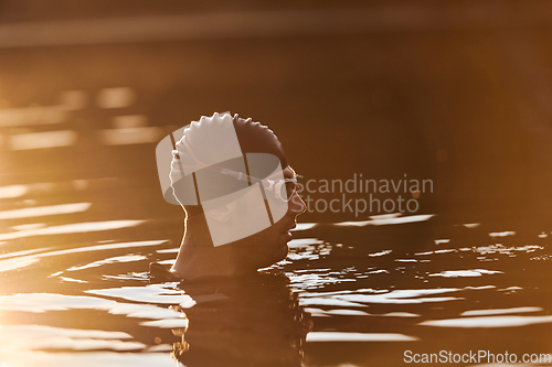 Image of A triathlete finds serene rejuvenation in a lake, basking in the tranquility of the water after an intense training session