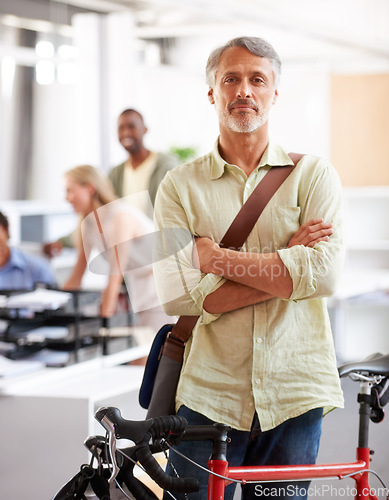 Image of Mature man, arms crossed and bicycle in office with portrait and manager of sustainable company. Ceo, boss and job with eco friendly commute in morning with smile in creative agency of professional