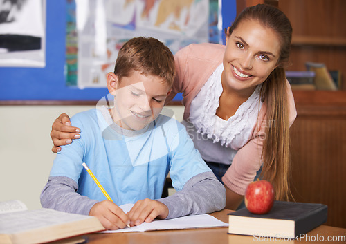 Image of Happy teacher, student and care in support for education, learning or tutor in classroom at school. Portrait of woman, mentor or teaching boy in writing, literature or test for exam or help in class