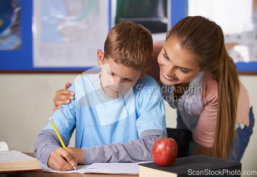 Image of Happy teacher, support and helping student in education, learning or classroom tutor at school. Woman, mentor or teaching boy in writing, literature or test for book exam, assistance or help in class