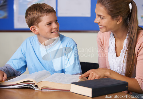 Image of Happy teacher, book and helping student in education, learning or classroom tutor at school. Woman, mentor or teaching boy in writing, literature or test for open exam, assistance or help in class