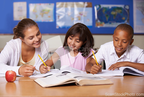 Image of Teacher, books and school kids in classroom, writing or learning together for development, studying or knowledge. Woman, children and help with notebook with support, teaching or education with smile