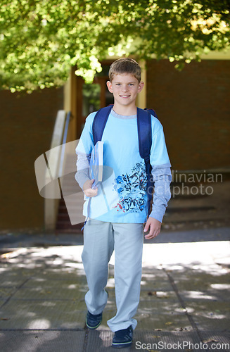 Image of Portrait, boy and book with backpack, outdoor and smile with knowledge, education and happy. Person, outside and student with childhood development, bag and kid with joy, cheerful and learning