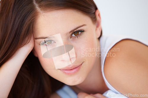 Image of Smile, calm and portrait of woman on bed for relaxing with positive, good and confident attitude. Happy, face and young female person from Canada laying and resting in bedroom of modern apartment.