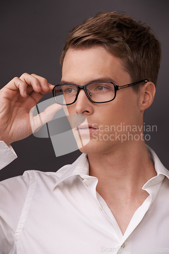 Image of Man, thinking and serious nerd with glasses, fashion or choice in eyewear on dark background of studio. Optometry, check and geek with spectacles, style and person with prescription lenses in frame