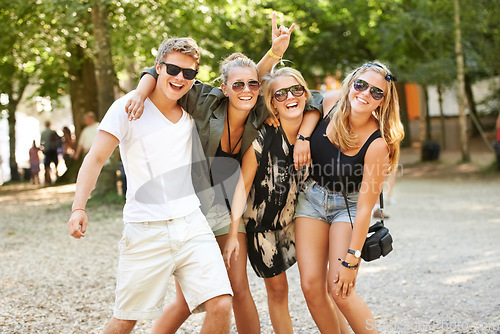 Image of Hug, celebration and friends at a park for festival, concert or happy social gathering. Face, fun and people in a forest with freedom, energy and excited for event, reunion or party with rocker hands