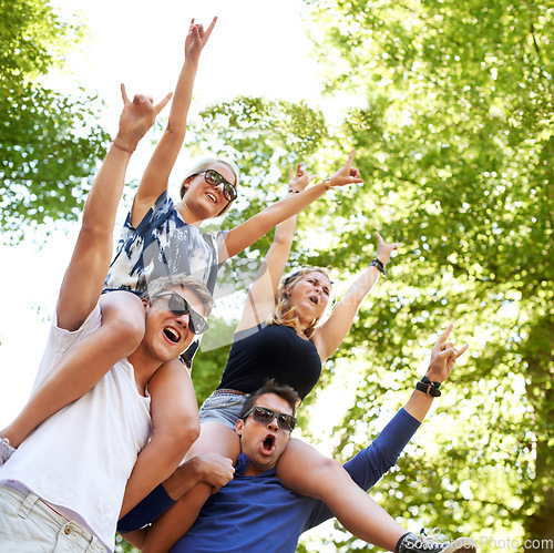 Image of Music, festival and carrying friends on shoulders with cheers of fans in celebration and freedom. Happy, people or sign for rock n roll at concert with trees above or men support girlfriends in woods