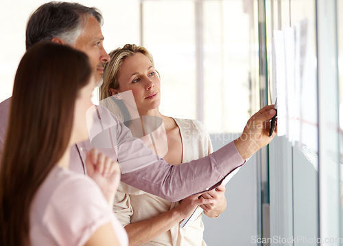 Image of Business people, teamwork and meeting for schedule planning, brainstorming or collaboration at office. Businessman and team looking at project plan on glass board for agenda or tasks at workplace