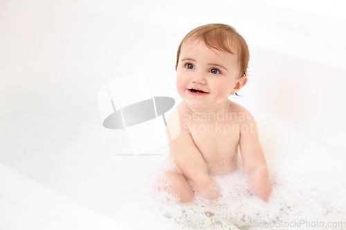 Image of Baby in bath with soap, water and clean fun in home for skincare, wellness and hygiene. Bubble bathtub, foam and happy child in bathroom with cute face, care and washing body of dirt, germs and smile