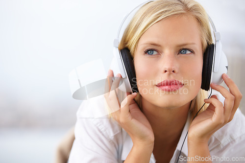 Image of Woman thinking, relax and listening to music with audio streaming service and mental health podcast at home on bed. Young student or person with ideas, vision and headphones for sound and inspiration