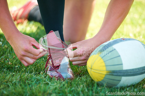 Image of Rugby, ball and sports with shoes of person on field for training, practice and challenge. Health, start and games with closeup of athlete tying laces on outdoor pitch for stadium and fitness