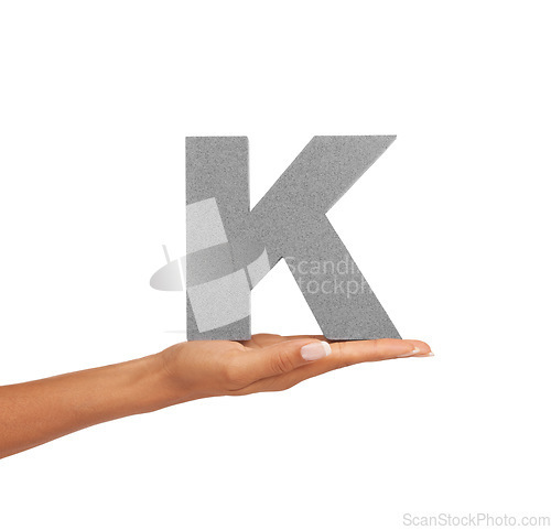 Image of Hand of woman, capital letter K and presentation of consonant isolated on white background. Character, font and palm with English alphabet typeface for communication, reading and writing in studio.