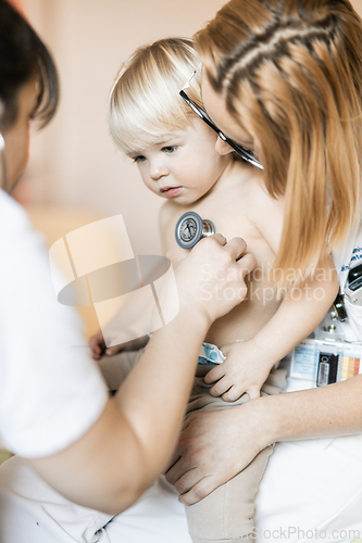 Image of Doctor holding stethoscope and listening to child's heartbeat. Regular checkout at pediatrician at clinic or hospital. Healthcare and medical concept.