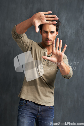 Image of Hands, selfie frame and portrait of man in studio for photography against grey background. Finger, border and face of male model with social media, profile picture and memory or screenshot gesture