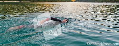 Image of A professional triathlete trains with unwavering dedication for an upcoming competition at a lake, emanating a sense of athleticism and profound commitment to excellence.