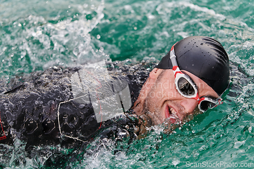 Image of A professional triathlete trains with unwavering dedication for an upcoming competition at a lake, emanating a sense of athleticism and profound commitment to excellence.