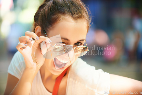 Image of Woman, portrait and sunglasses for outdoor wink fun at summer festival in nature for camping, social gathering or explore holiday. Female person, face and eyewear for sunny, travel or happy adventure