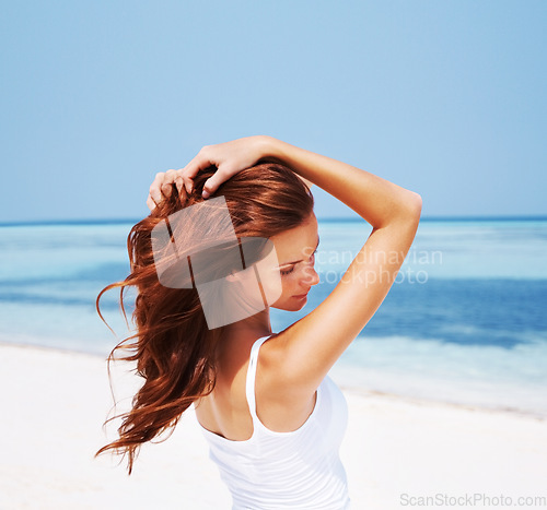 Image of Woman, relax and beach with vacation, hair care and holiday by sea with freedom. Female person, beauty and outdoor with calm and ginger hairstyle in the sun in summer with travel and ocean on trip