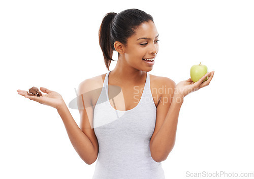 Image of Man, apple and chocolate for healthy food choice or thinking of diet on a white background. African person with sweets versus green fruit in palm for detox decision or lose weight challenge in studio