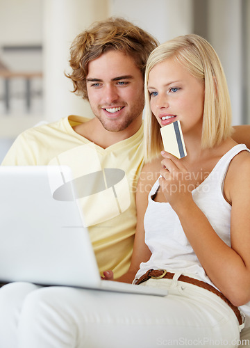 Image of Couple, credit card and thinking on laptop for online shopping, loan choice or digital money on sofa at home. Young woman and man on computer for internet banking, website payment or e commerce ideas