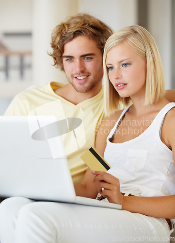 Image of Couple, credit card and laptop for online shopping, loan registration or digital money on sofa at home. Young woman and man relax on computer for internet banking, website payment or e commerce order