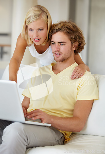 Image of Search, laptop and couple on a sofa with social media, movies or streaming at home together. Online shopping, internet and people in a living room checking ecommerce website deal for December sale