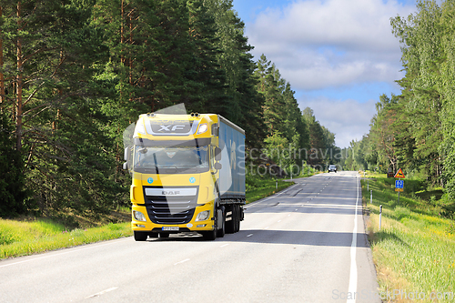 Image of Yellow DAF XF Truck Delivers Goods on Sunny Summer Morning