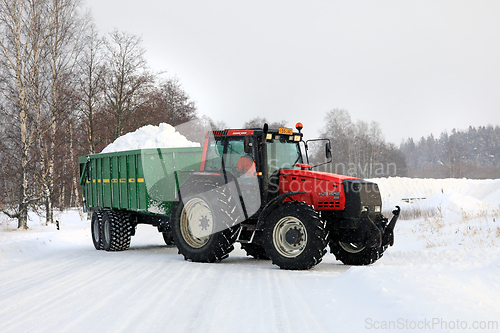 Image of Red Tractor Transports Snow to Snow Dump