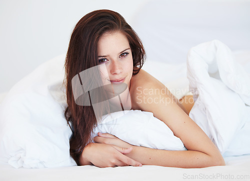 Image of Woman, bed and portrait in morning with smile, relax and holiday with calm in apartment, hotel or home. Girl, person and lying in bedroom, house and wake up with cover, duvet or blanket on vacation