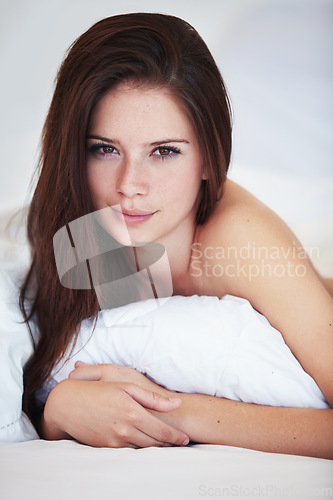 Image of Woman, bed and happy in portrait in morning, relax and holiday with calm in apartment, hotel or home. Girl, person and lying in bedroom, house and wake up with cover, duvet and blanket on vacation