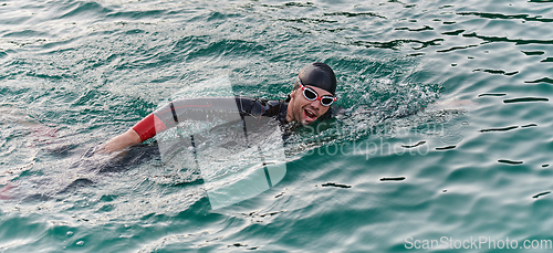 Image of A professional triathlete trains with unwavering dedication for an upcoming competition at a lake, emanating a sense of athleticism and profound commitment to excellence.