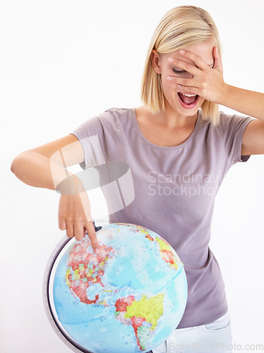 Image of Wow, guess or pointing and a woman with a globe in studio on a white background for destination choice. World, planet and hand gesture to a location on earth for overseas travel decision or selection